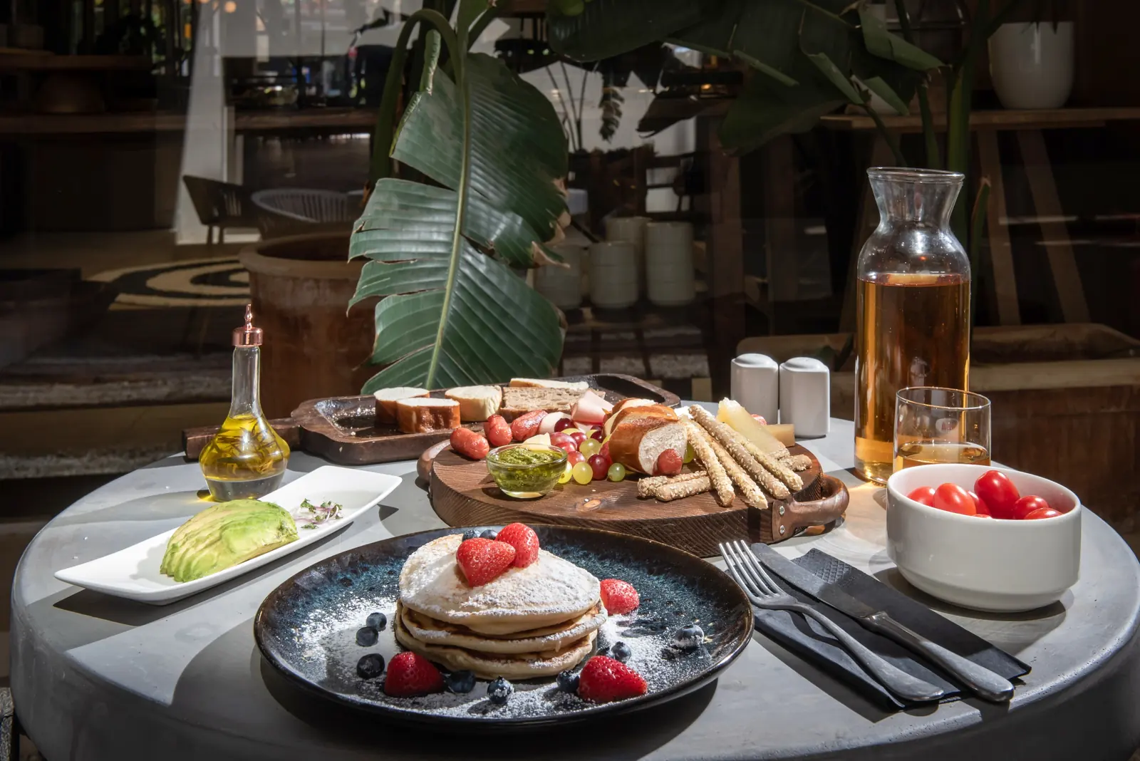 Pancakes with strawberries on a blue ceramic plate with a bread board