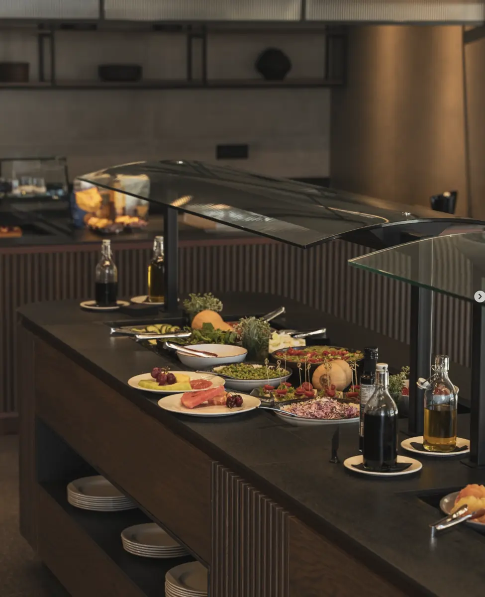 Chilled buffet counter with glass sneeze guard and salads